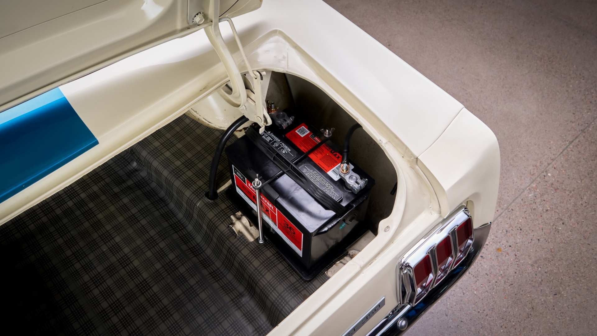 Motorcraft battery sitting in the trunk of a blue and white vintage car