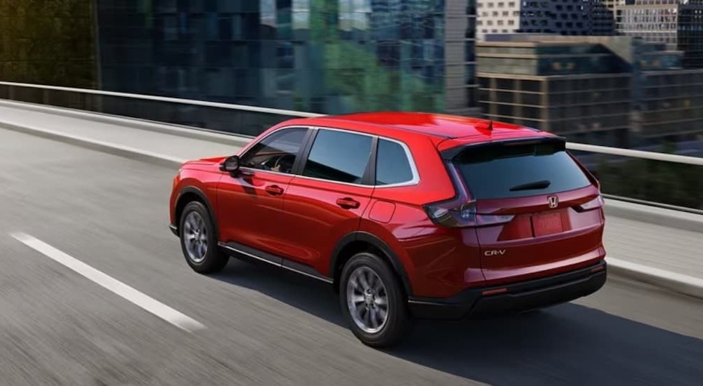 A red 2024 Honda CR-V is shown driving to visit a Honda dealer in Middletown.