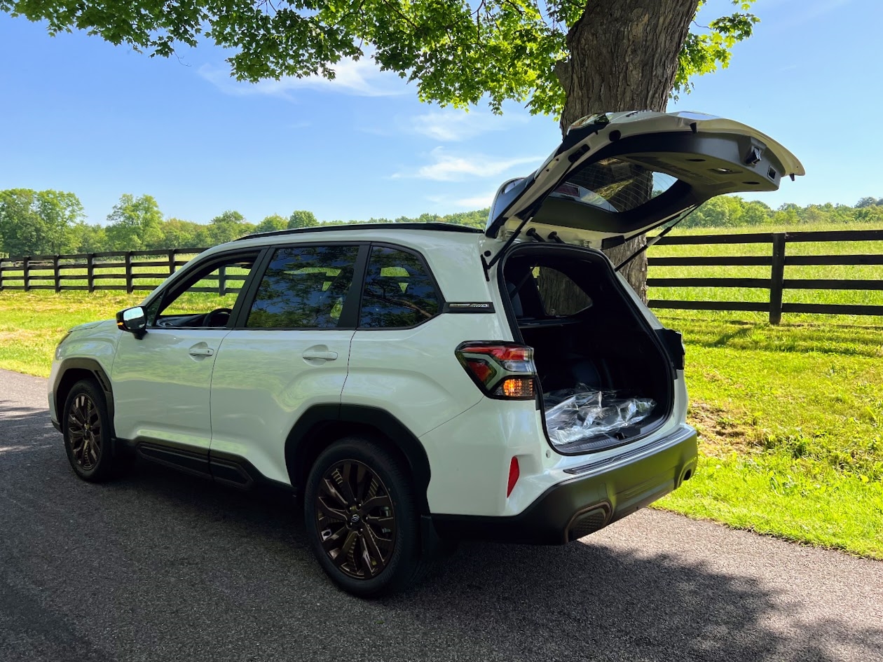 Rear view of a white 2025 Subaru Forester with an open hatchback.
