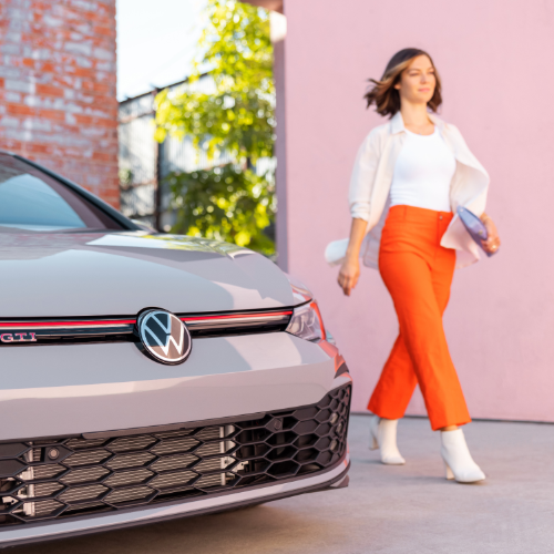 woman walking on side of her new Volkswagen car