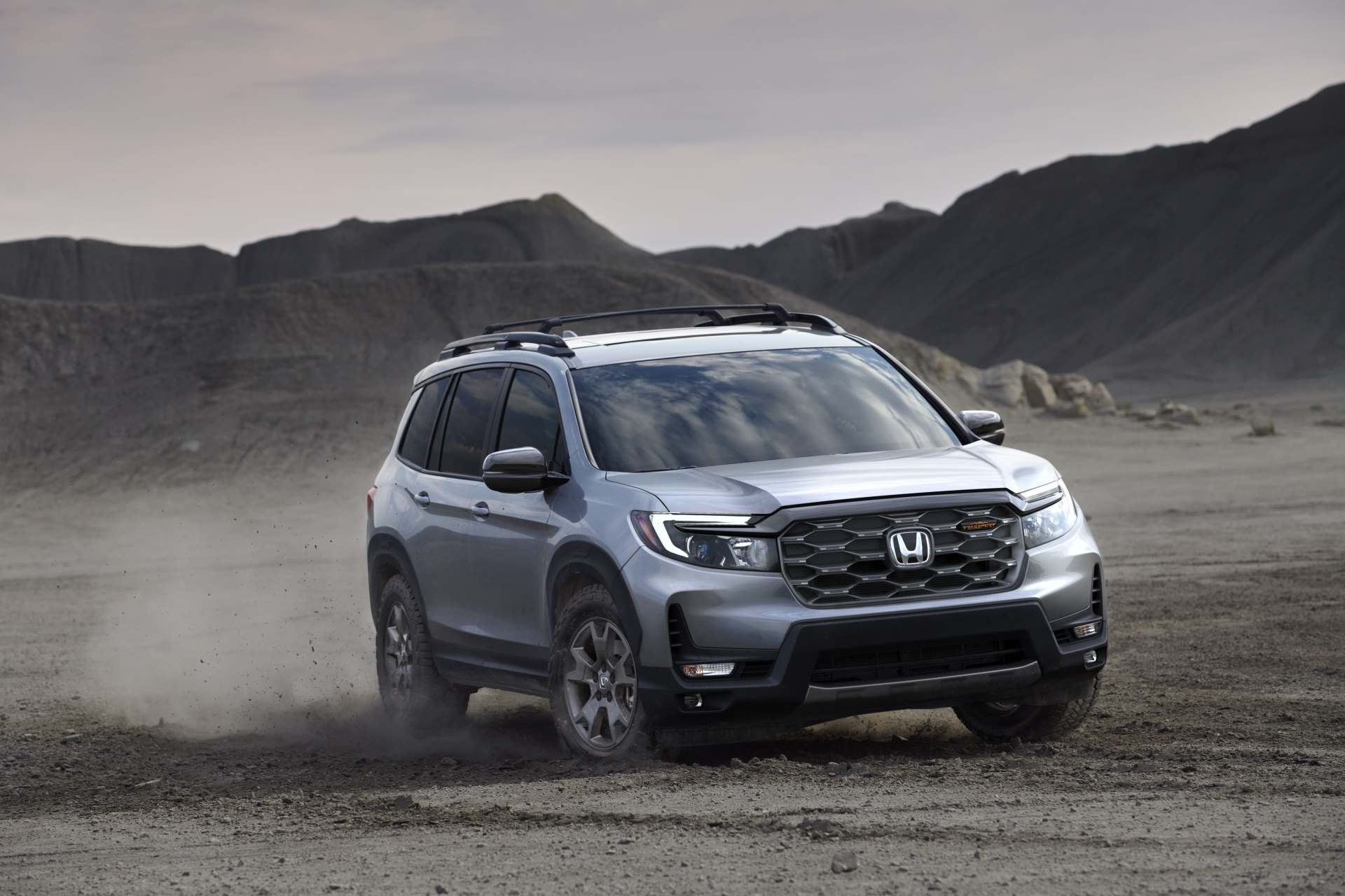 Honda Passport churning sand in the desert at dusk.