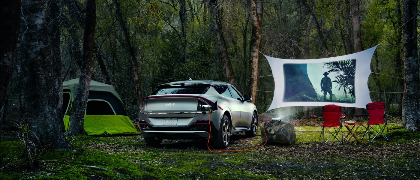 2024 Kia EV6 in the woods powering a projector