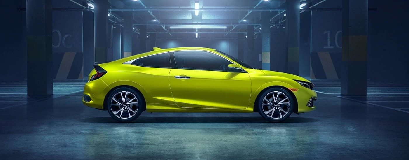 A neon yellow 2019 Honda Civic Touring is shown from the side in a warehouse after leaving a used Honda dealer near Kirkland.