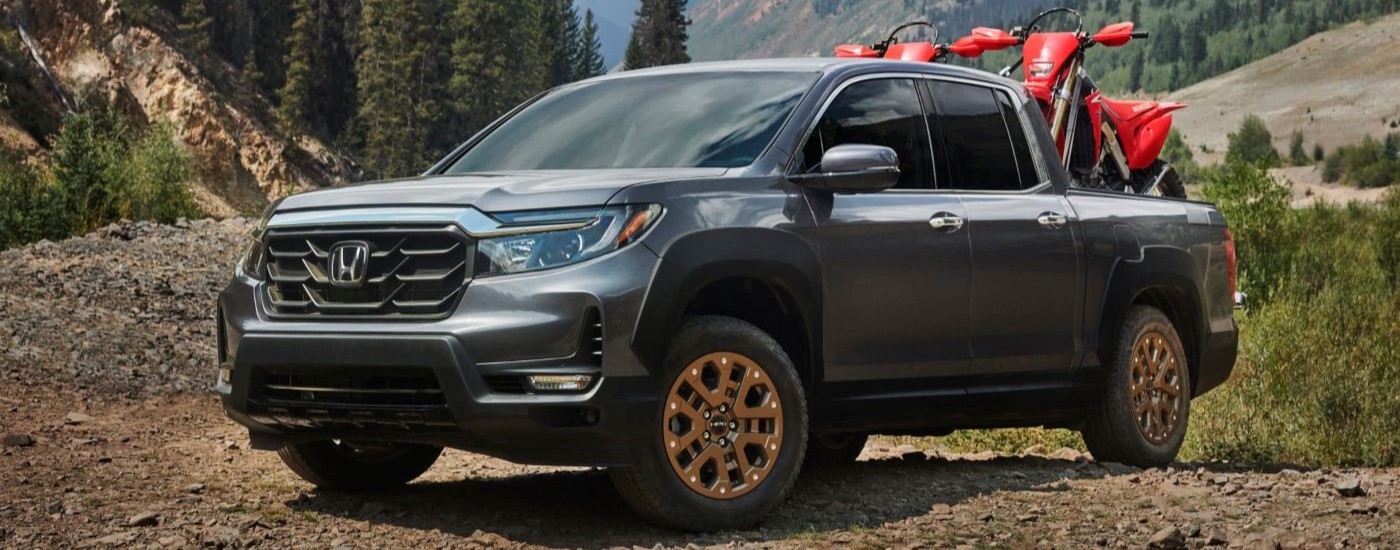 A dark grey 2021 Honda Ridgeline HPD is shown with dirt bikes in the bed.