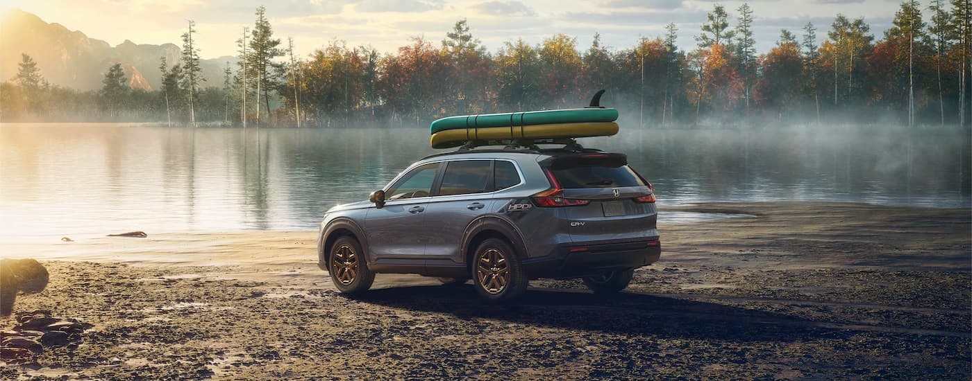 A blue 2023 Honda CR-V HPD EX is shown next to a lake.