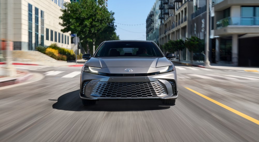 Head-on view of a silver 2024 Toyota Camry XSE driving through the city.