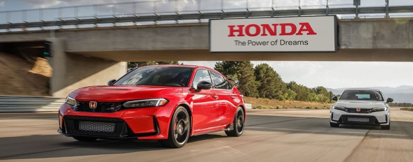 A red and white 2023 Honda Civic Type R are shown driving on a road to visit a Redmond Honda dealer.