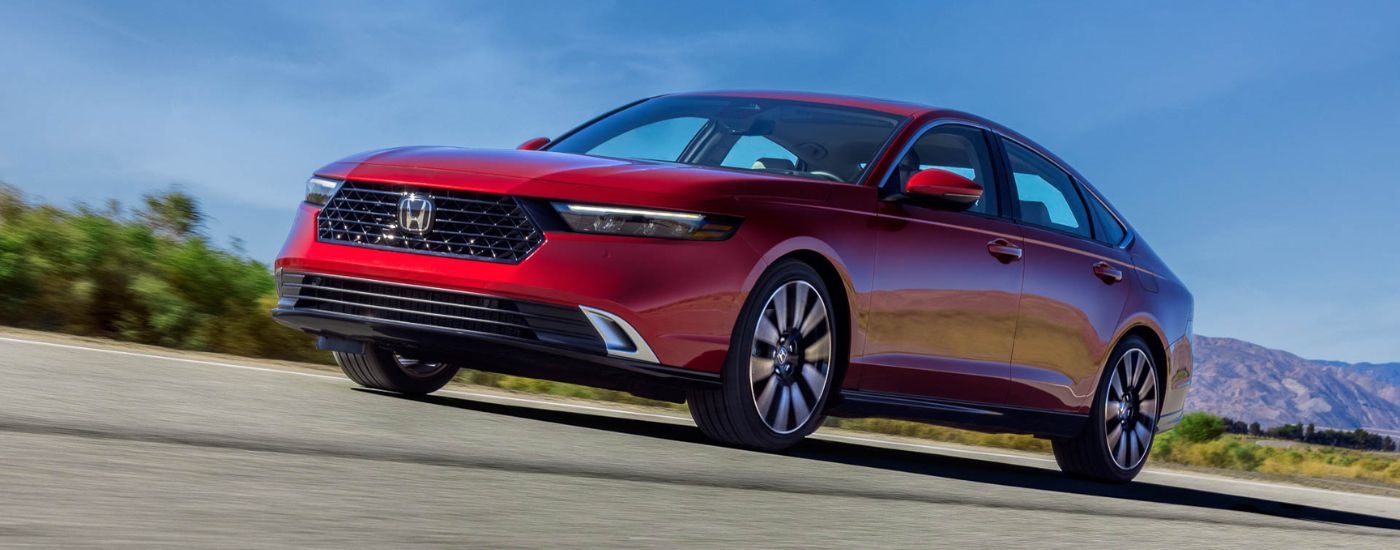 A red 2023 Honda Accord is shown from the front at an angle after leaving a Honda dealer near me.