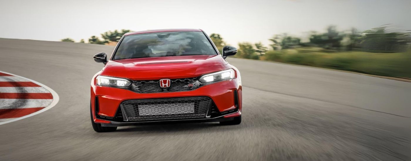 A red 2023 Honda Civic Type R is shown from the front on a racetrack.