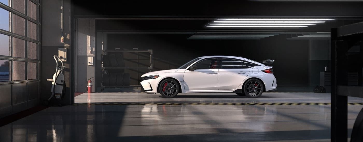 A white 2023 Honda Civic Type R is shown in a garage.