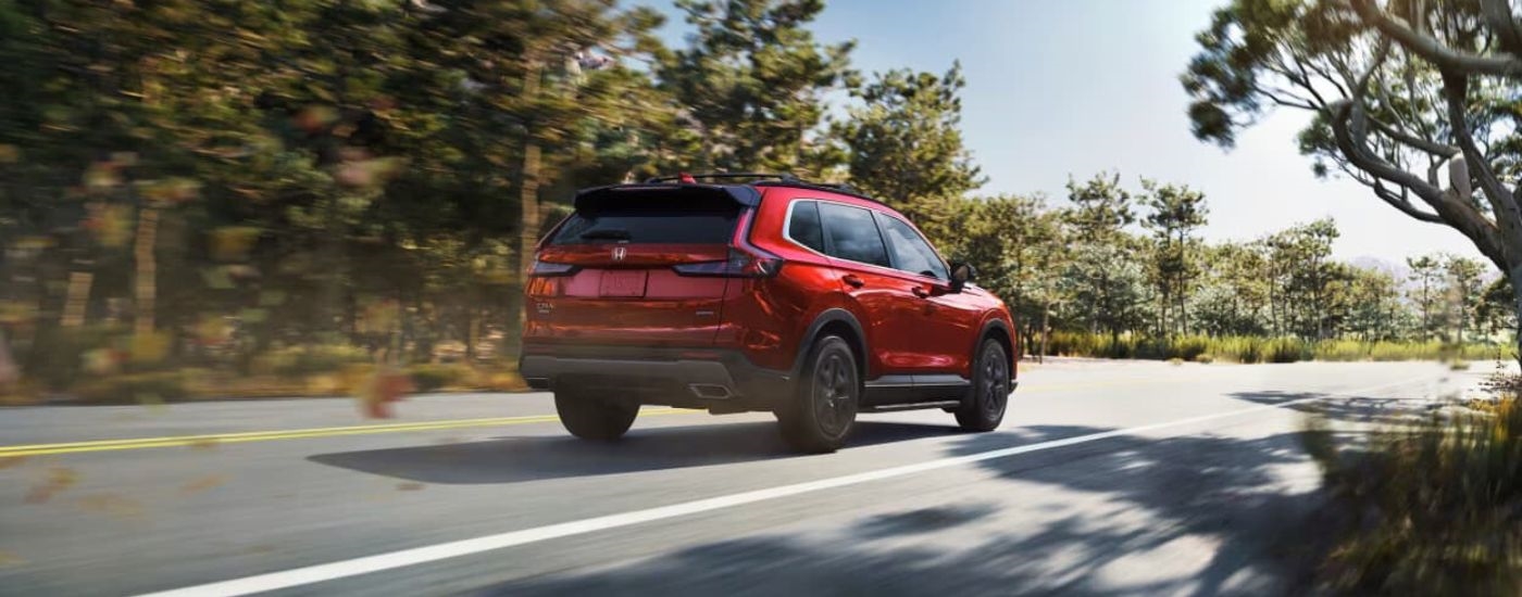 A red 2024 Honda CR-V is shown on an open road after leaving a Honda Dealer in Everett, WA.