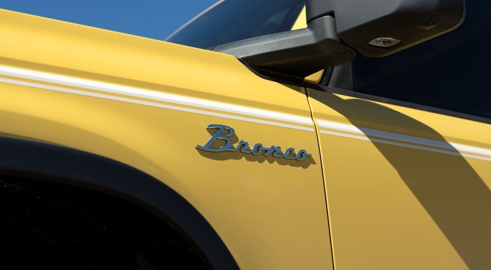 A close-up on the Bronco badge of a yellow 2024 Ford Bronco.