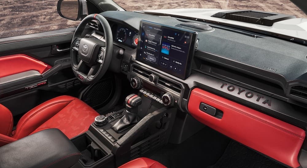 A view of the red and black interior of a 2024 Toyota Tacoma TRD Pro.