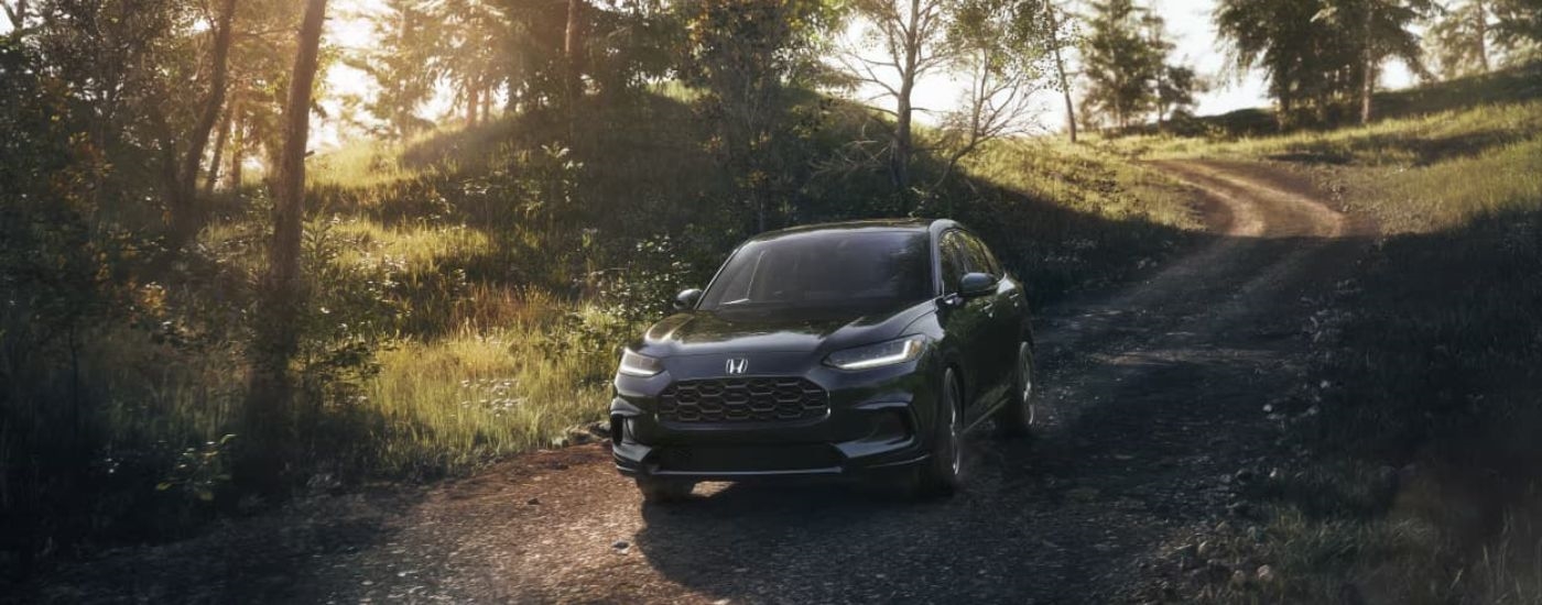 A black 2023 Honda HR-V for sale near Lynnwood, WA is shown driving on a trail.