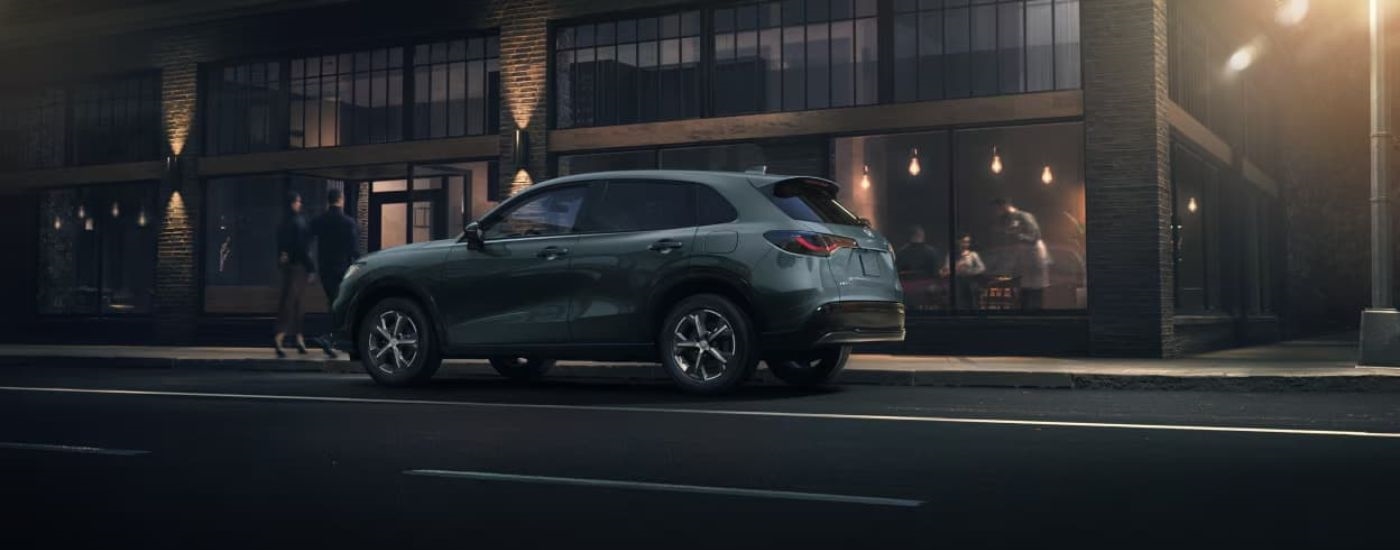 A grey 2023 Honda HR-V is shown parked in front of a resturant.