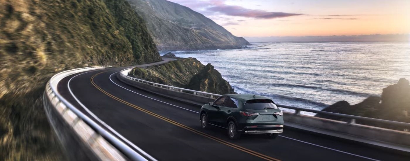 A grey 2023 Honda HR-V is shown driving on a coastal road.