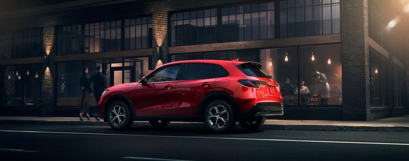 A red 2023 Honda HR-V EX-L is shown parked in front of a restaurant.