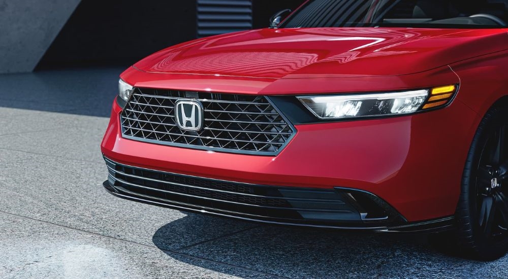 A close up shows the front end of a red 2024 Honda Accord.
