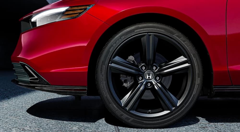 A close up shows the black rim on a red 2023 Honda Accord Sport-L.