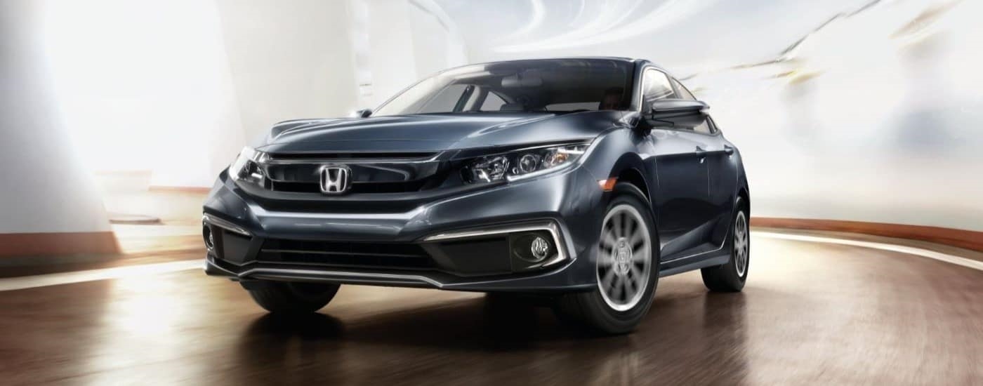 A gray 2019 Honda Civic is shown driving to view used cars for sale.
