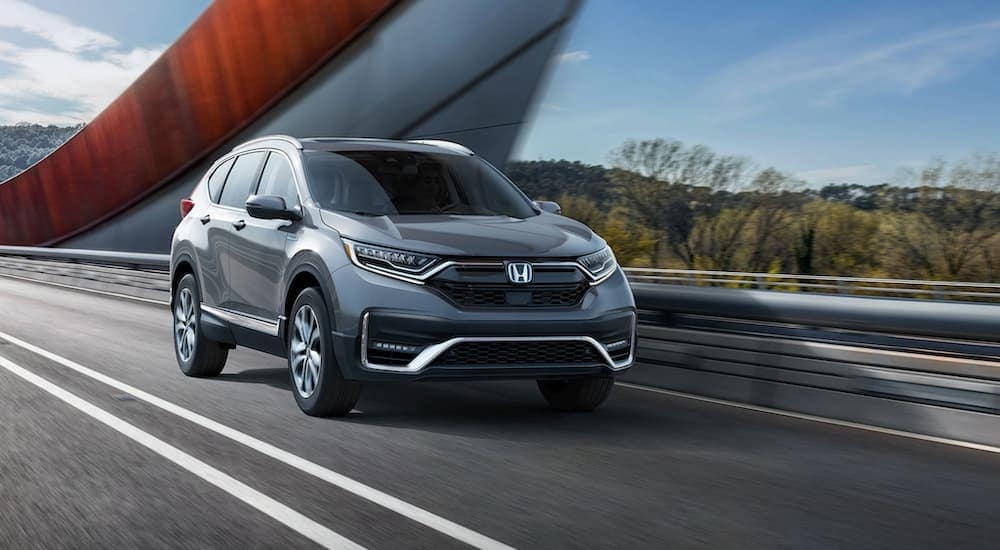 A grey 2020 Honda CR-V Hybrid is shown from the front at an angle after leaving a dealer that has used cars for sale.
