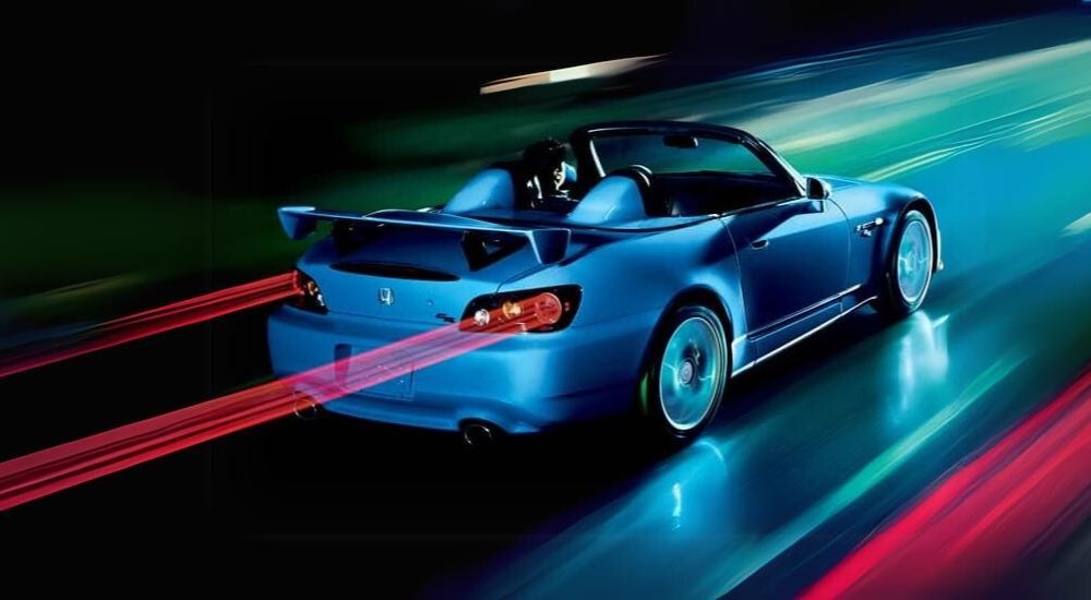 A blue 2008 Honda S2000 CR is shown driving to a Honda dealer near Shoreline, WA.