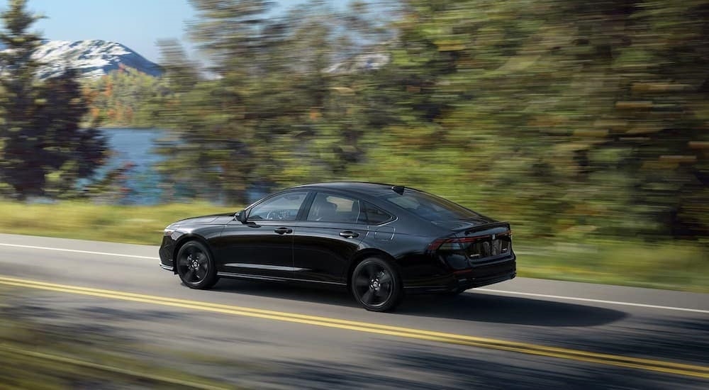 A black 2023 Honda Accord Hybrid is shown from the rear at an angle after leaving a dealer that has a Honda Accord Hybrid for sale in Everett, WA.