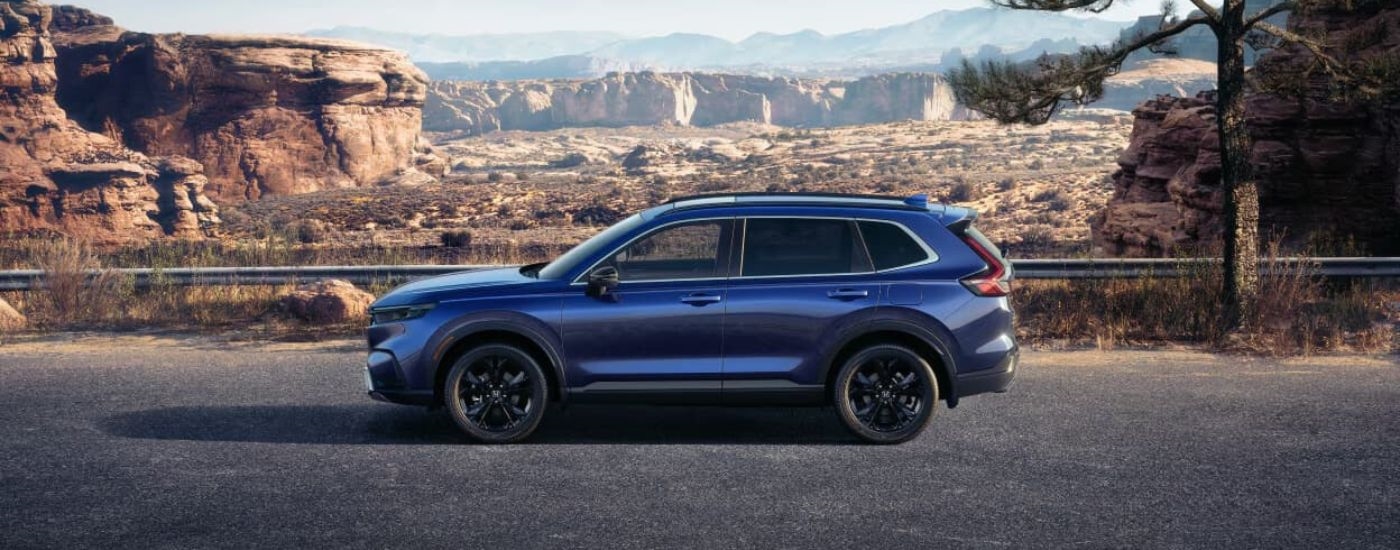 A blue 2024 Honda CR-V is shown from the side.