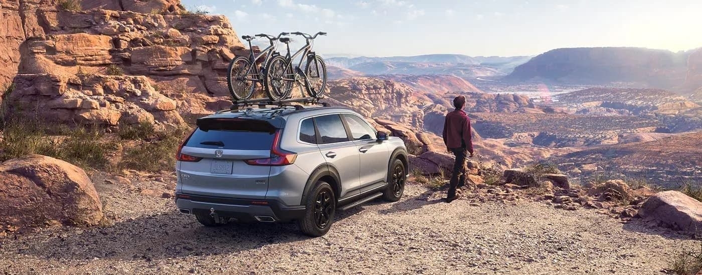 A rear view of a grey 2023 Honda CR-V Sport Touring Hybrid overlooking a canyon.