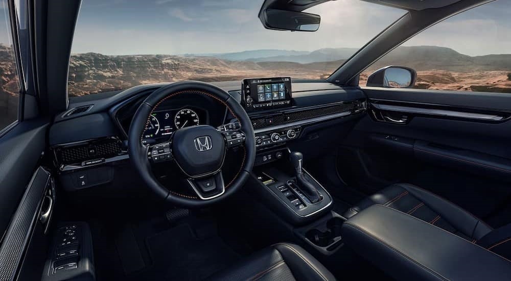 The black interior and dash of a 2024 Honda CR-V Hybrid is shown.