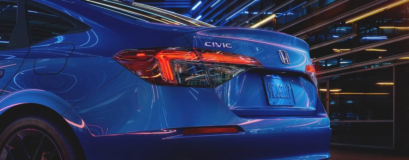 The rear brake lights on a blue 2023 Honda Civic Sport are shown.