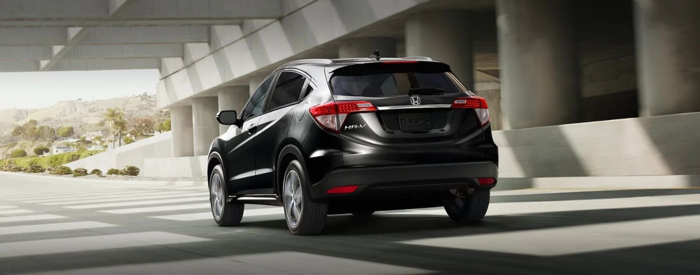 A black 2021 Honda HR-V is shown driving to look at used SUVs for sale.