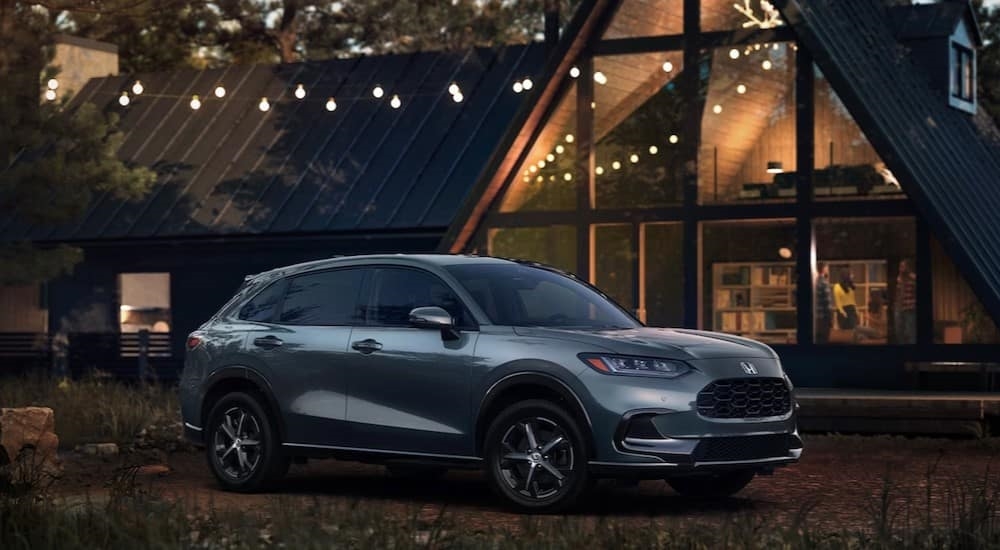 A silver 2024 Honda HR-V is shown parked near an A-frame cabin.