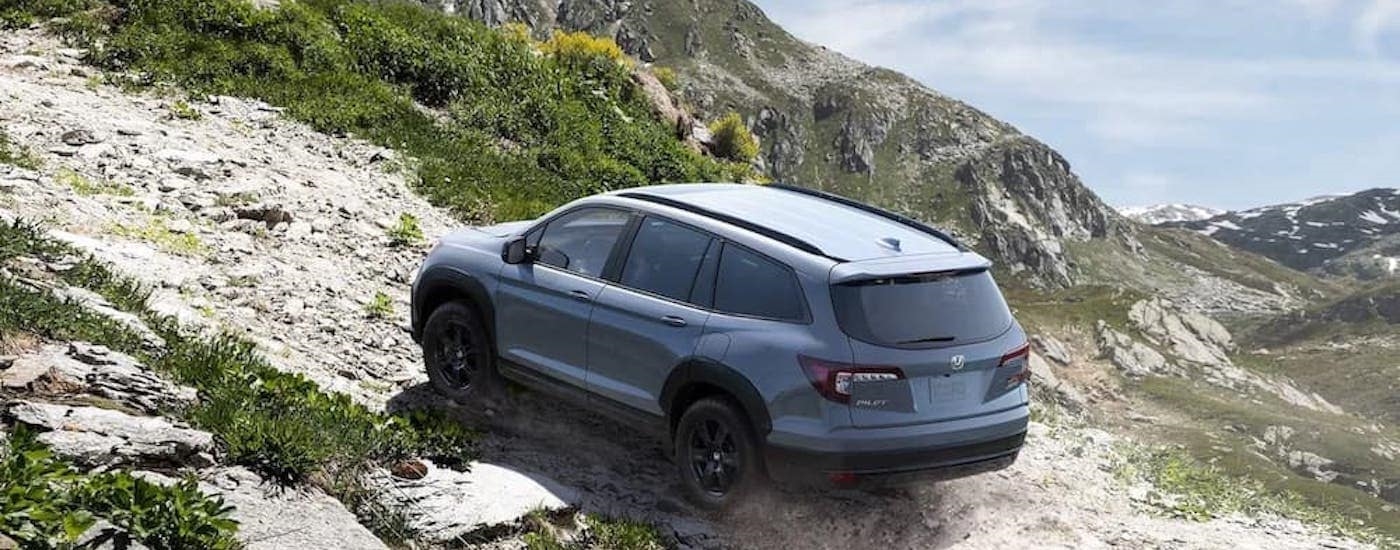 A grey 2023 Honda Pilot is shown from the rear at an angle.