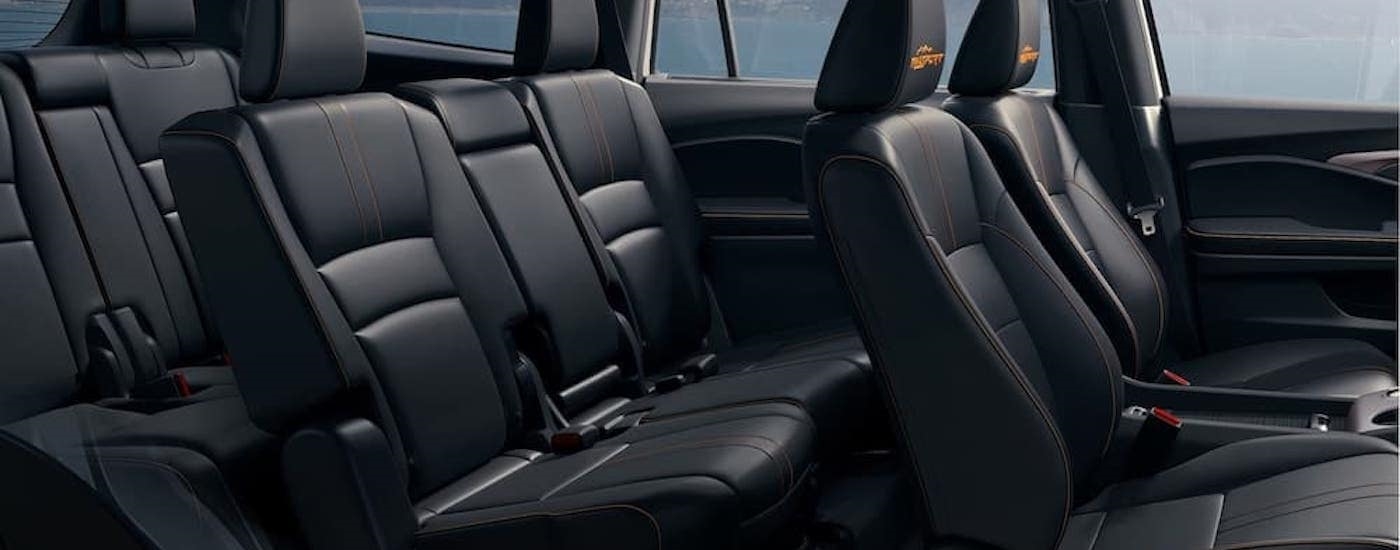 The black interior of a 2022 Honda Pilot Trailsport is shown from the passenger side.
