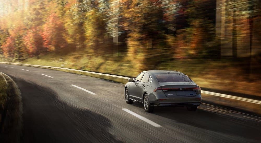 A grey 2024 Honda Accord is shown driving from a Seattle used Honda dealer.