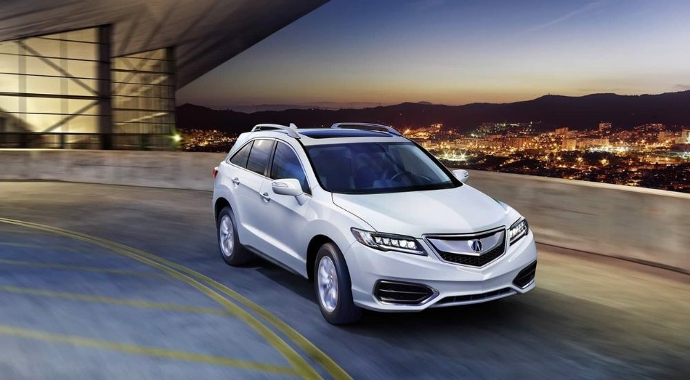 A white 2017 Acura RDX is shown rounding a corner.
