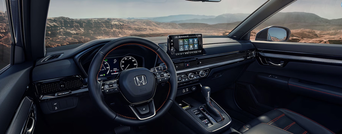 The black interior and dash in a 2024 Honda CR-V Hybrid is shown.
