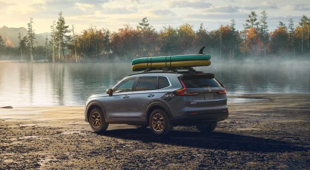 A gray 2024 Honda CR-V EX with HPD Package is shown parked near water.
