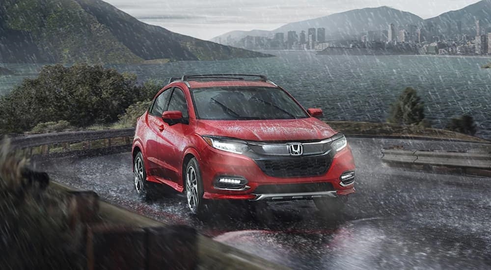 A red 2020 Honda HR-V is shown driving from a used Honda dealer near Kirkland.