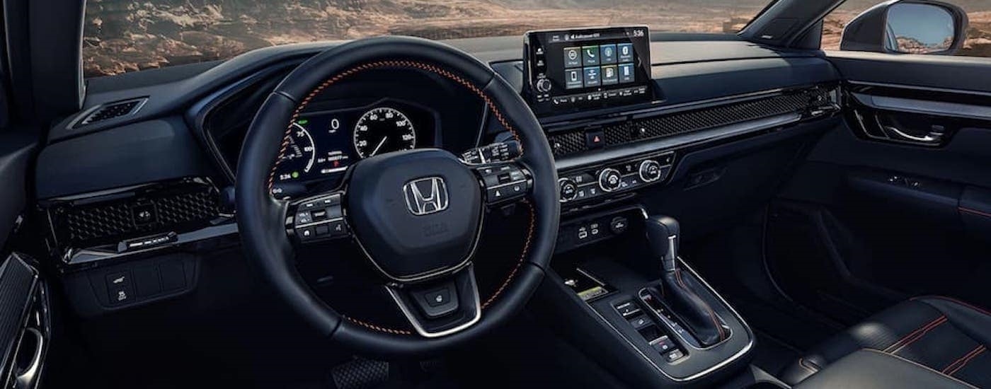 The steering wheel and dashboard in a 2023 Honda CR-V.