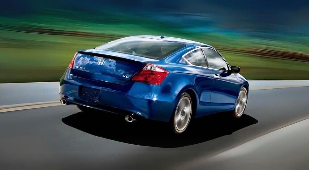 A blue 2009 Honda Accord is shown driving on an open road.