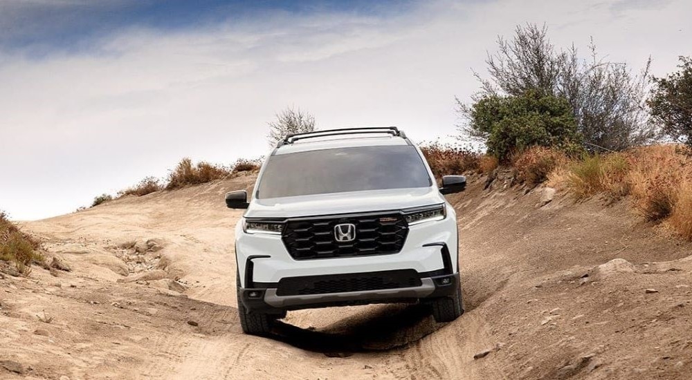 Head-on view of a white 2024 Honda Pilot Trailsport off-roading.