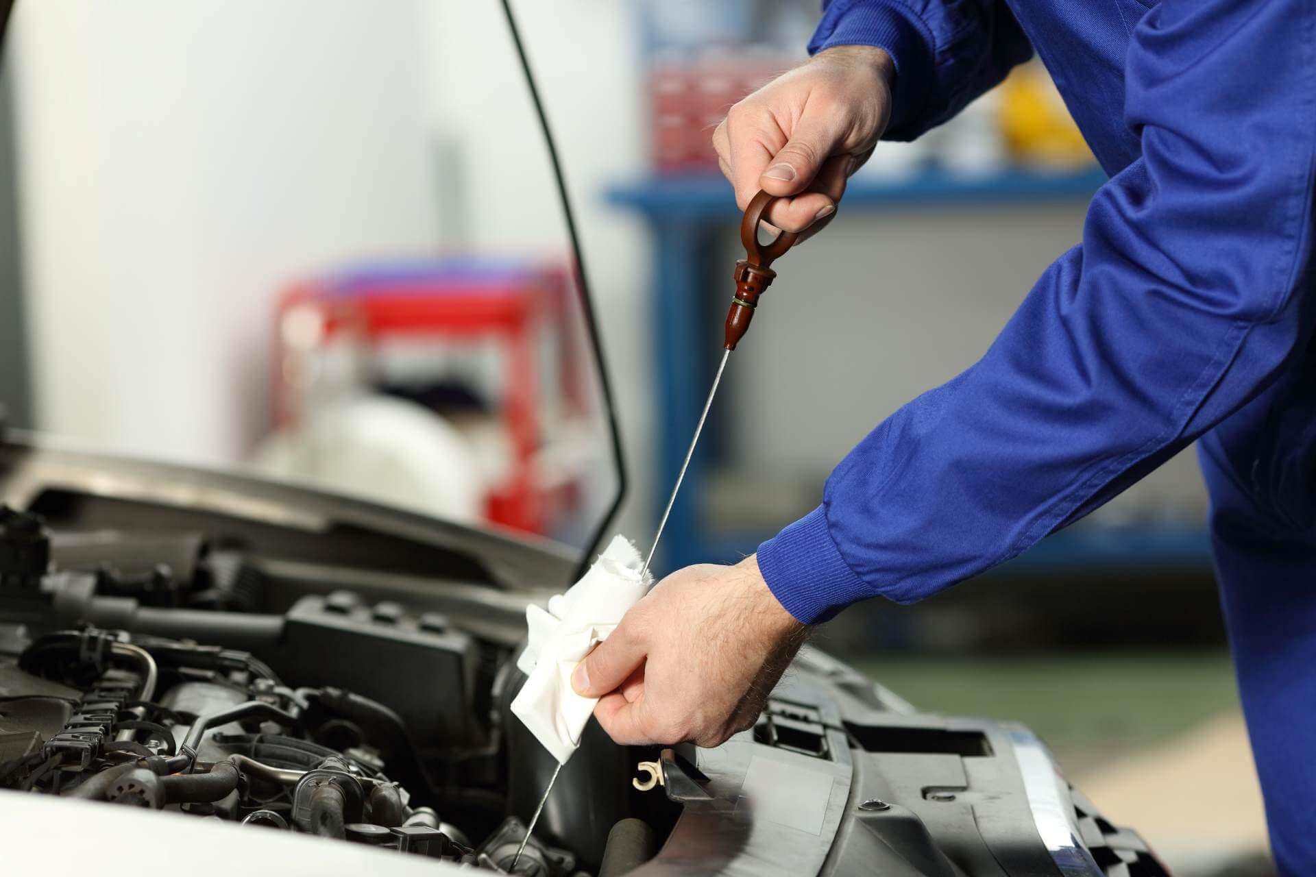 Chula Vista Ford service technician using dipstick.