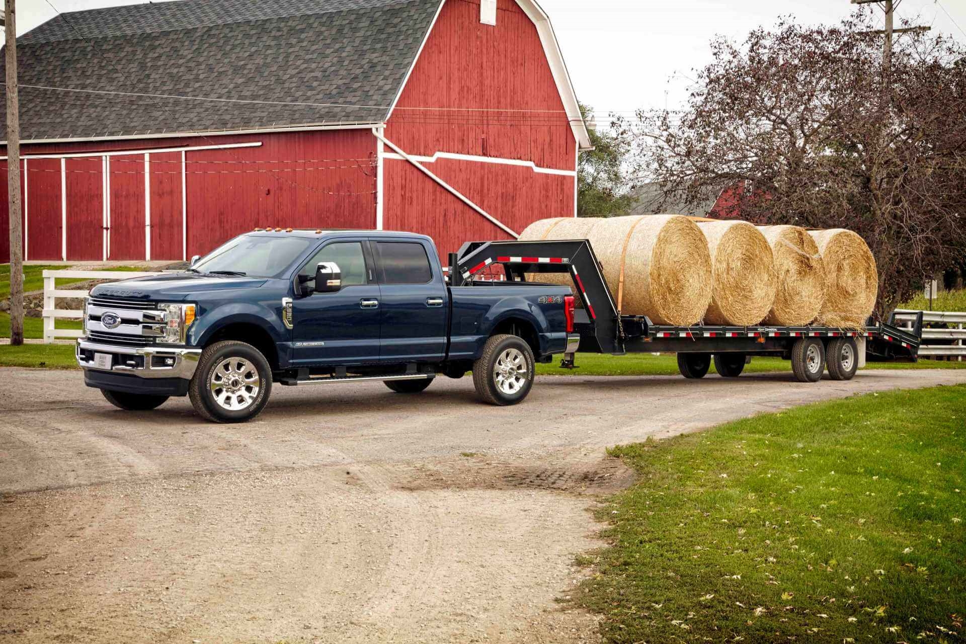 An older, used Ford F-250 Lariat Crew Cab 4x4 single-rear-wheel pickup on a farm.