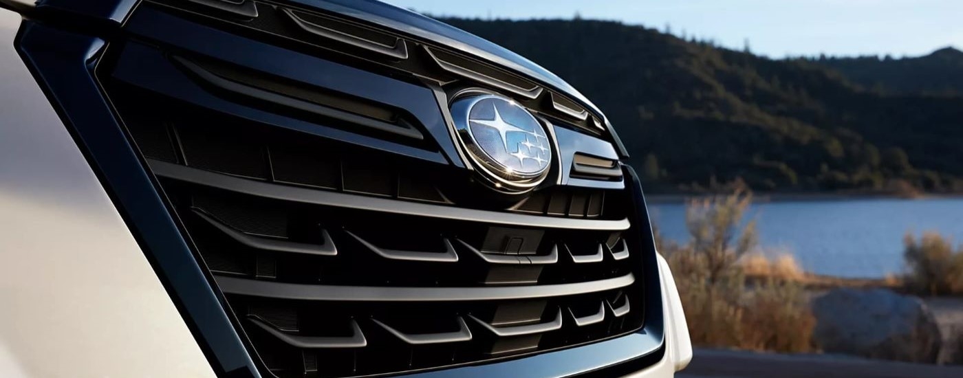 A close-up on the grille of a tan 2024 Subaru Forester.