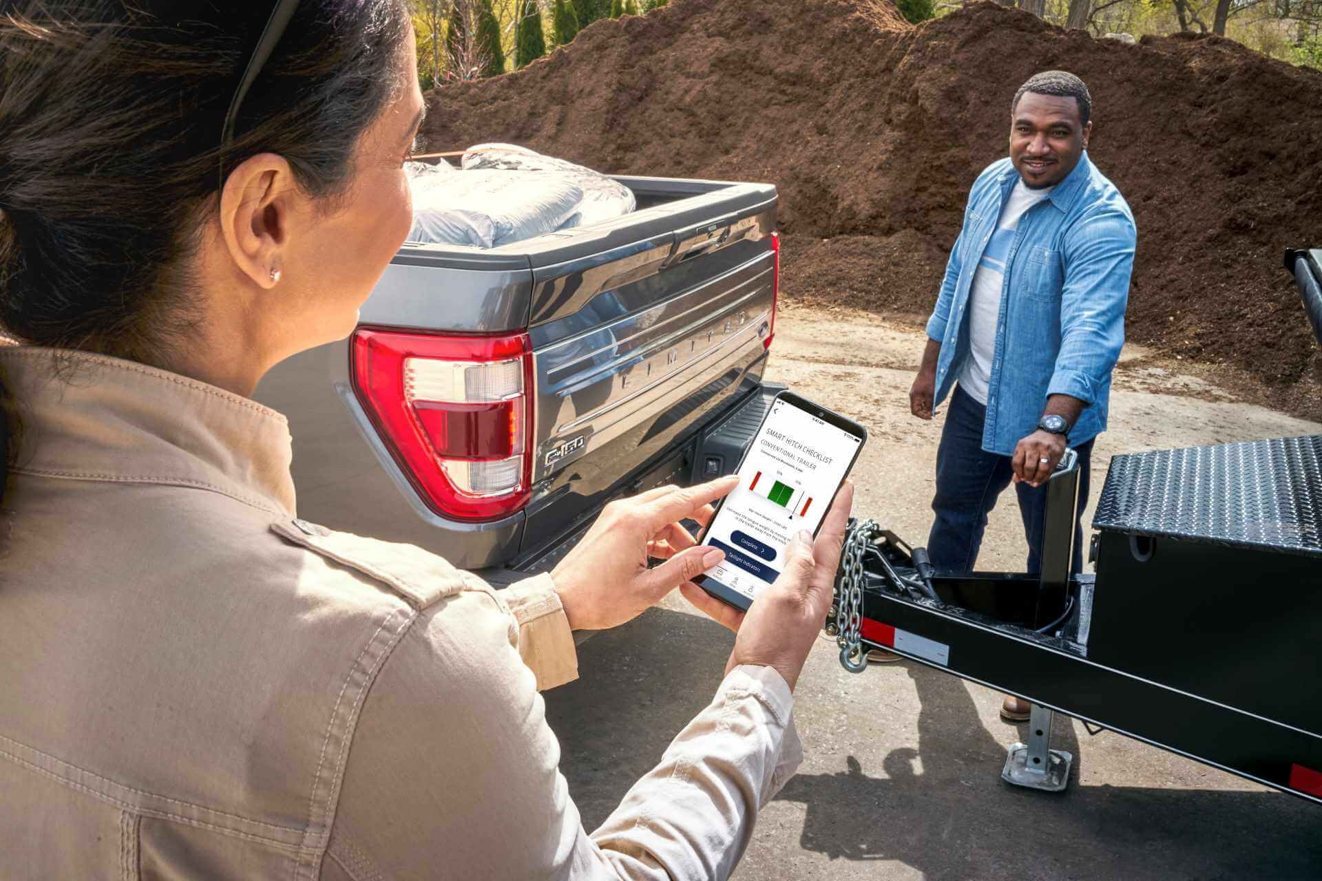 Satisfied Ford customers engaging Smart Hitch technology with larger trailer and Ford F-150.