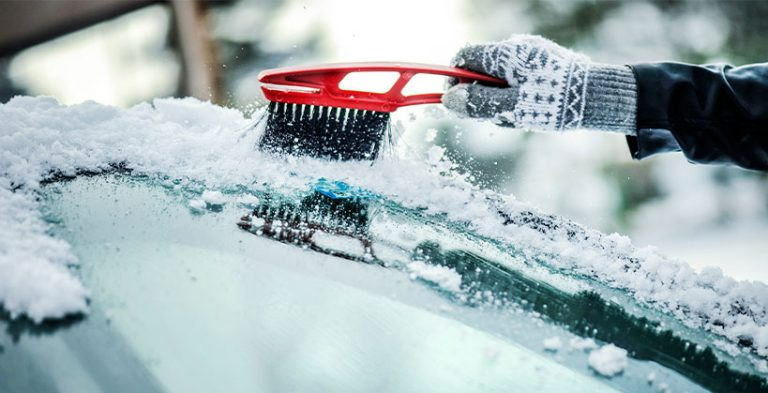 Brushing snow off vehicle