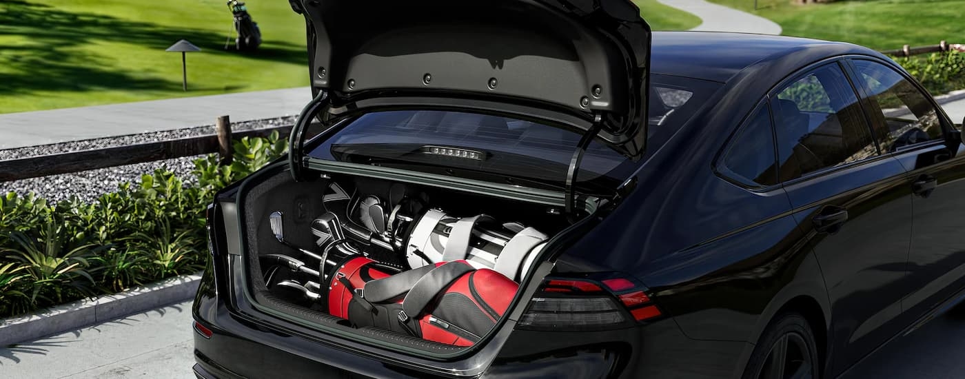 A set of golf equipment is in the rear cargo area of a 2024 Honda Accord.