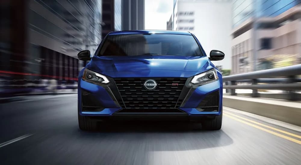 A blue 2024 Nissan Altima SR is driving on a highway.